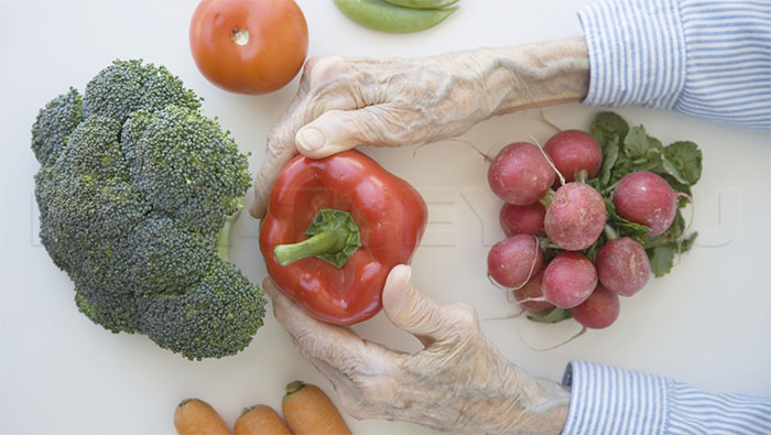 Руки пожилого человека и овощи - фото